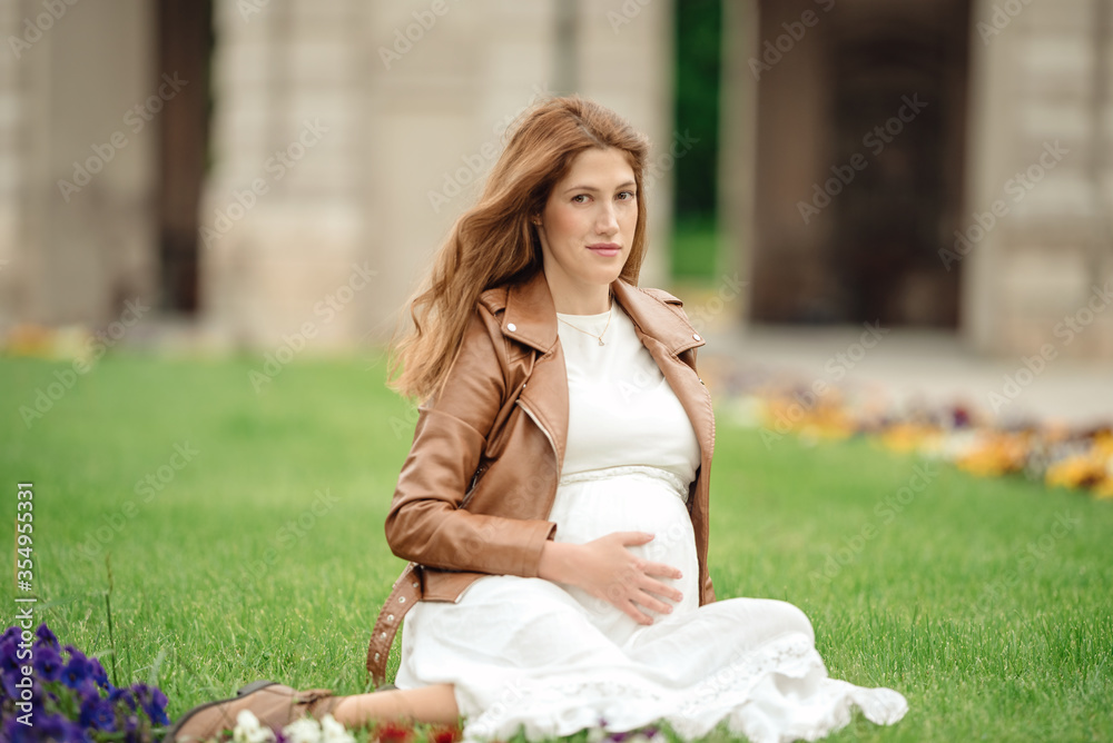 Charming pregnant woman relaxing in the park Charming pregnant woman relaxing in the park