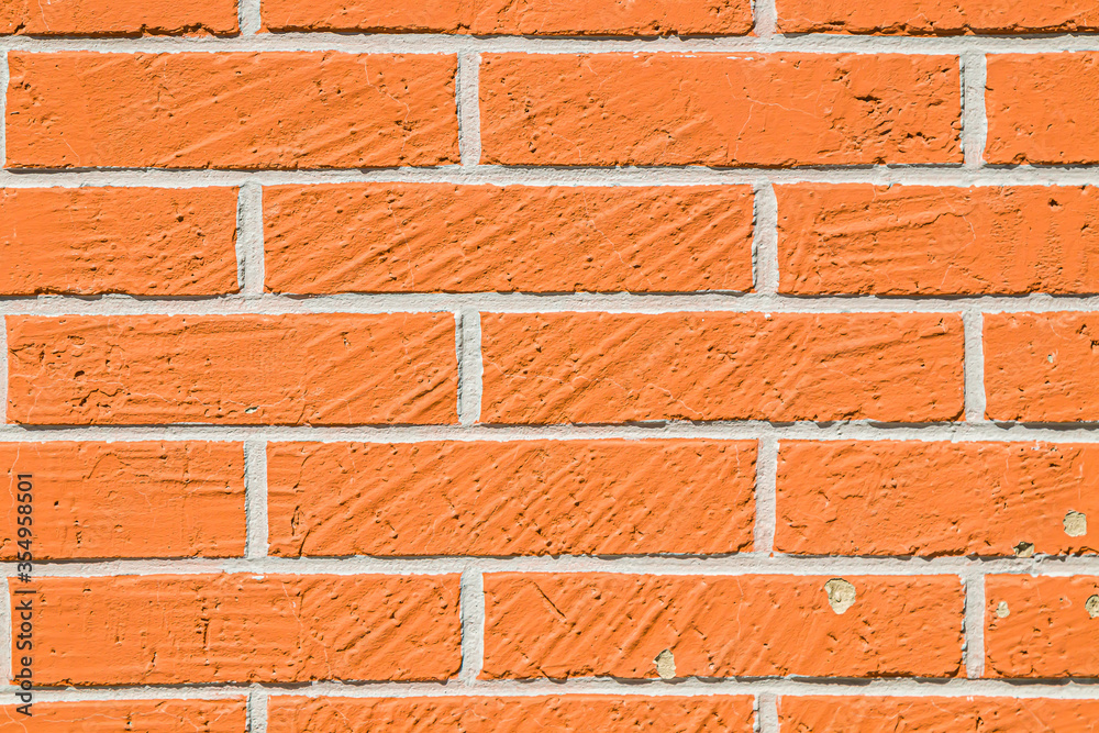 Obraz premium The structure of the wall is due to the spontaneous relief in the form of stripes. Abstract background Artificial stucco in the form of a brick as a background.