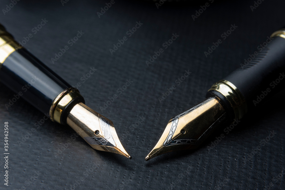 Beautiful fountain pen. under exposed photo on a black background Beautiful fountain pen. under exposed photo on a black background