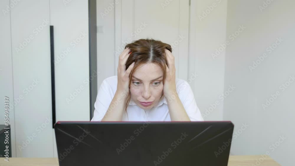 Sad wWoman reading content on her laptop feeling getting Shocked Sad wWoman reading content on her laptop feeling getting Shocked