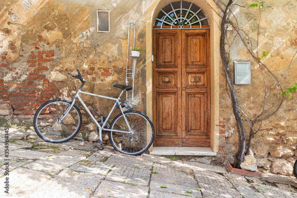 A bicycle rests against an old building in a Tuscan village. 