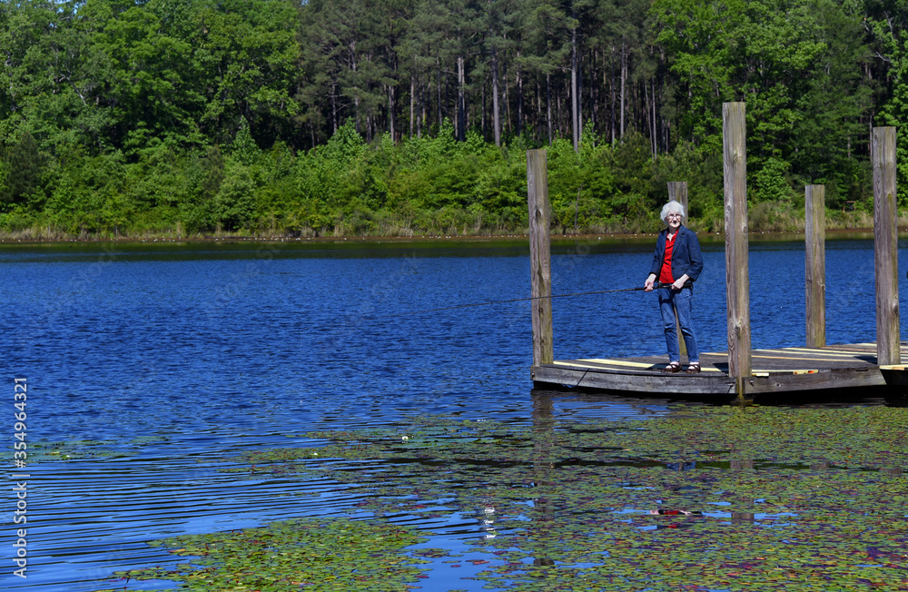 Elderly Fisherwoman Enjoys a Day on the Lake Elderly Fisherwoman Enjoys a Day on the Lake