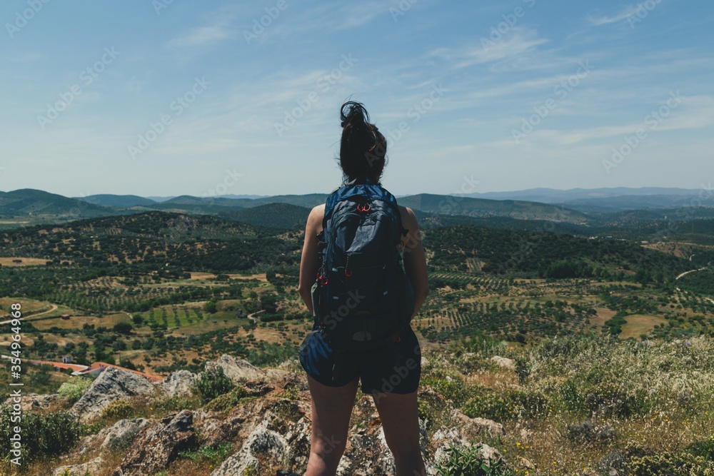 Rear view of a young woman with a backpack in the mountain hiking Trekking in the mountain. Rear view of a young woman with a backpack in the mountain hiking Trekking in the mountain.