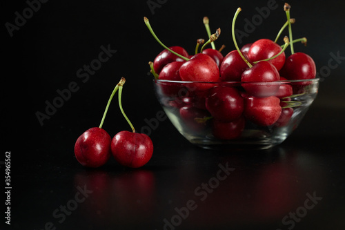 Spring red cherries on black background selective focus cherry