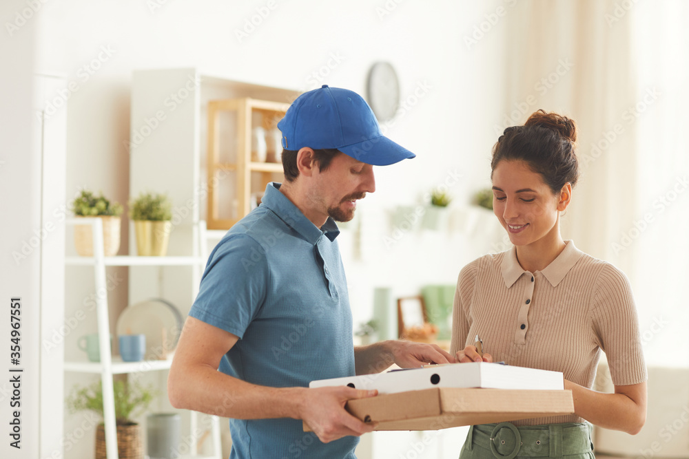 Young woman ordering the pizza and signing delivery at home Young woman ordering the pizza and signing delivery at home