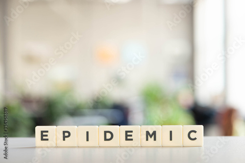 white cubes with epidemic lettering on white desk, covid-19 concept
