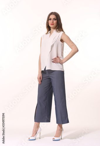 business woman executive posing in official sleeveless blouse , culottes trousers