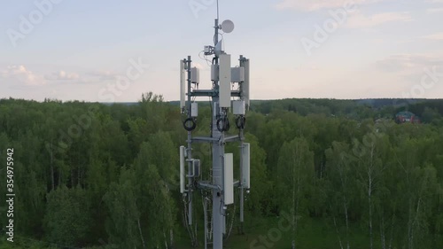Cellular and Internet tower with antennas and Dish Tv for transmitting 3G, 4G or 5G signals, aerial shot.