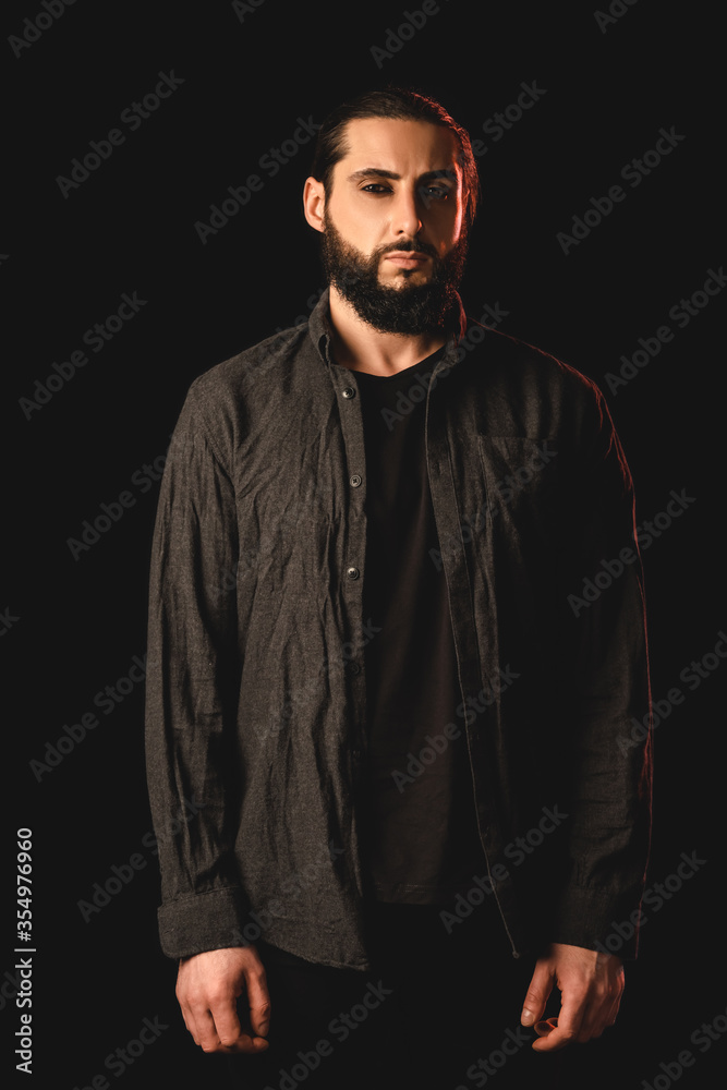 Bearded muslim man looking at camera isolated on black