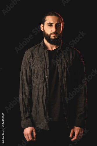 Bearded muslim man looking at camera isolated on black
