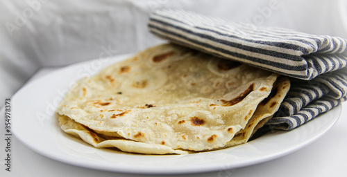 Slika na platnu Classic homemade flour tortilla's on white plate wrapped in a cloth