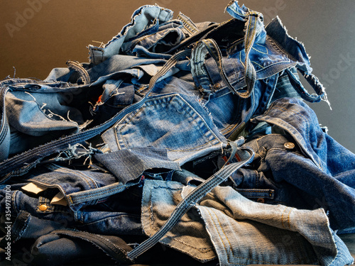 Pile of old blue jeans ready for recycling in the circular economy.  Room for text.