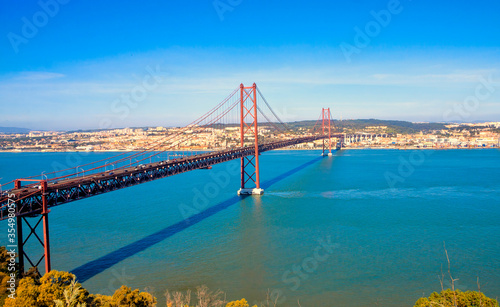  25th of April Bridge (Ponte 25 de Abril) on Tagus river in Lisbon, Portugal. Red bridge. Famous landmarks of Lisbon.
