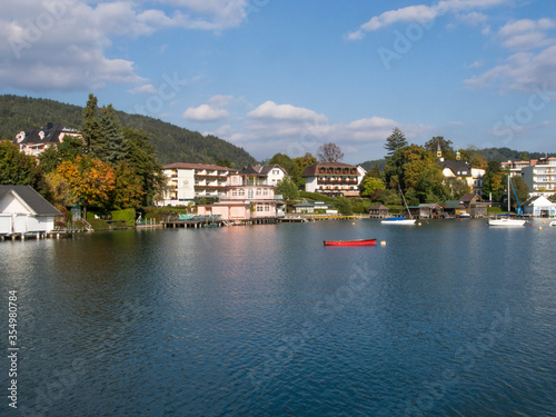 Hotels and other buildings lining the shore of beautiful blue W  rthersee in Austria