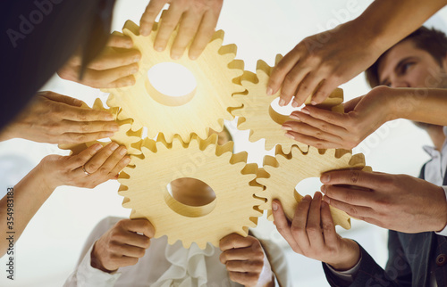 Group of businessmen with gears at the table at the workplace in the office.