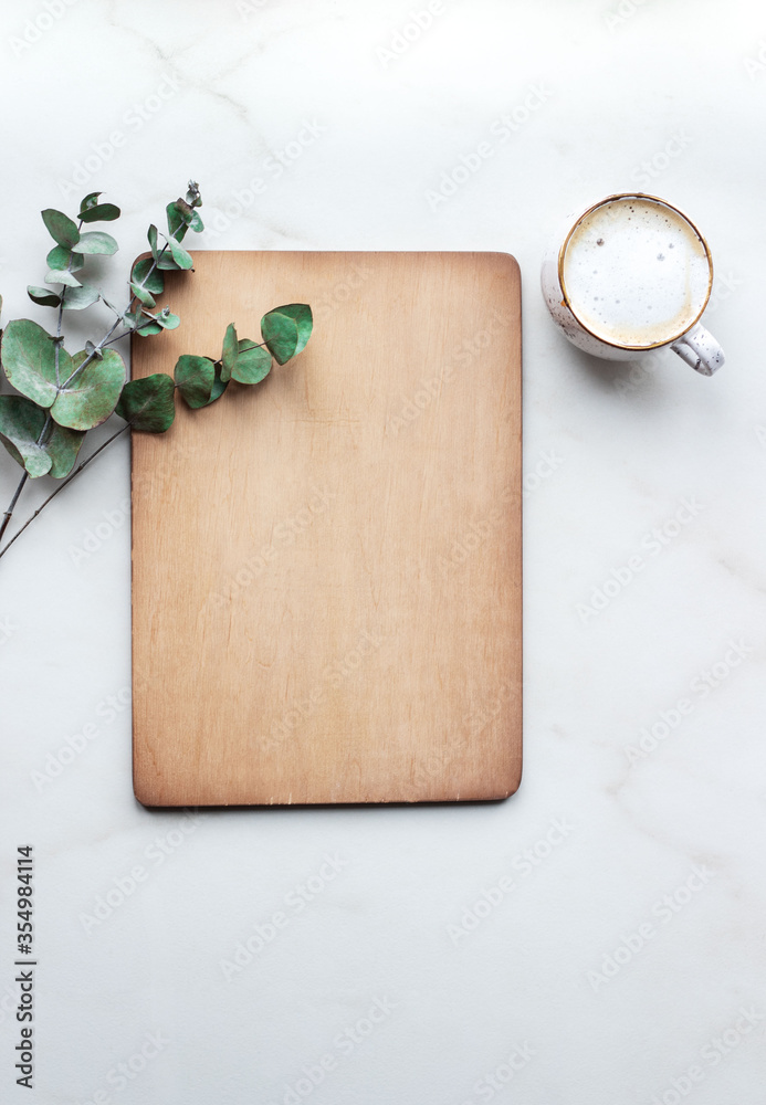 Office desk with Clipboard wood mockup , coffe cup and eucalyptus leaves.