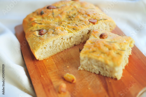 prepared and cut with a knife Focaccia with garlic and rosemary on a wooden cutting board
