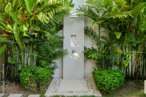 Exterior design of outdoor shower in garden of luxury pool villa, house, home feature rain shower head and garden landscape