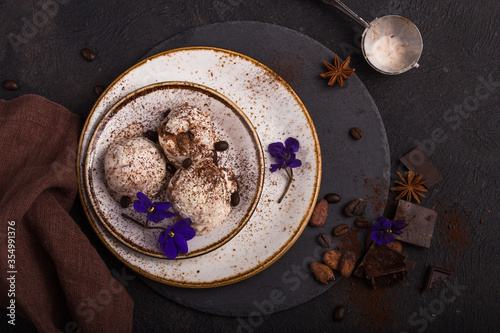 Chocolate ice cream scoops  in white bowl, chocolate and mint decoration. Summer food concept with copy space.