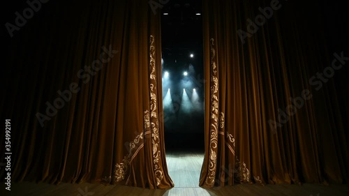 Curtain Opens. Empty theater stage with velvet curtains with spotlights.