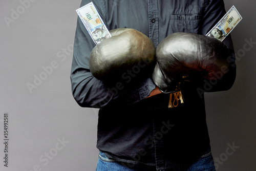 man in leather boxing gloves holds money dollars. business concept, safety