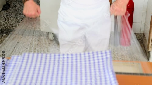 Woman packed washed and ironed laundry in the protective foil