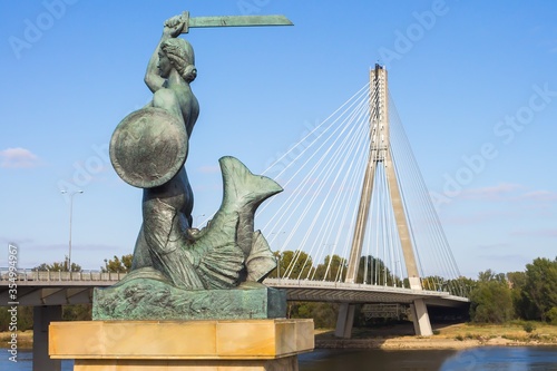 Mermaid of Warsaw by the Vistula River with Swietokrzyski Bridge in the background