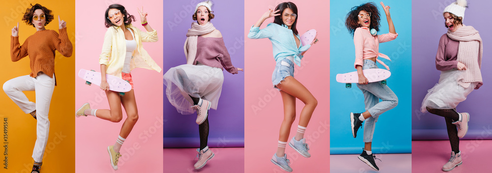 Full-length portrait of carefree girl in white pants jumping on orange background. Romantic lady with wavy hair dancing in knitted sweater.