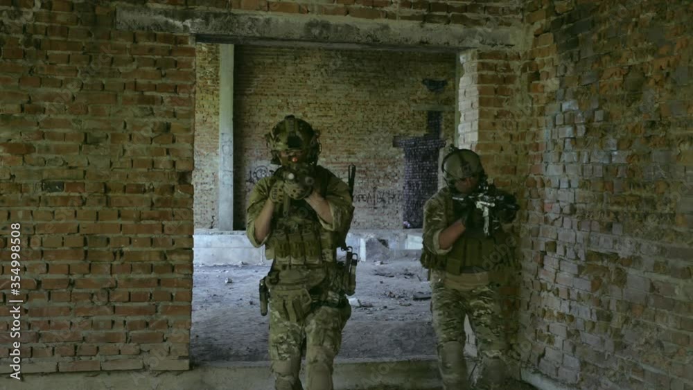 Two air soft men go through the door hole training fight in urban territory. Tactics rules Two air soft men go through the door hole training fight in urban territory. Tactics rules