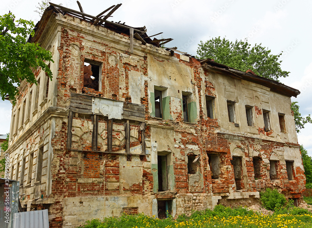 Side view of an old abandoned stone building of the 19th century with ruined windows
