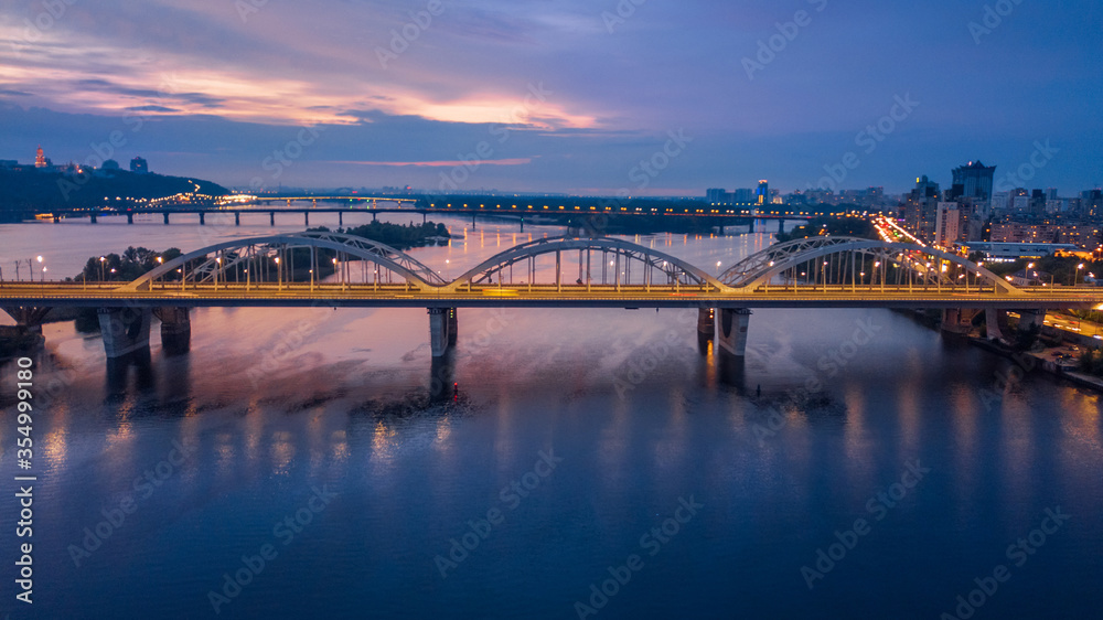 aerial night city view, luminous buildings and bridge. Drone shot.