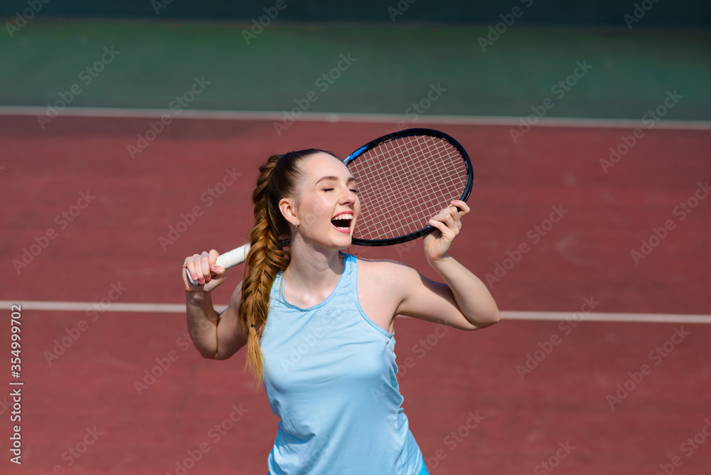 Sexy girl tennis player holding tennis racket on the court. Young woman is playing tennis.