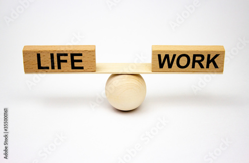 Wooden swing with the inscription work and life on wooden blocks. The concept of the balance of life and work.