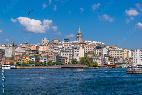Cityscape of Karaköy district with famous Galata Tower and the seagull flying over the Golden Horn during the daytime. Karaköy, Istanbul, Turkey 