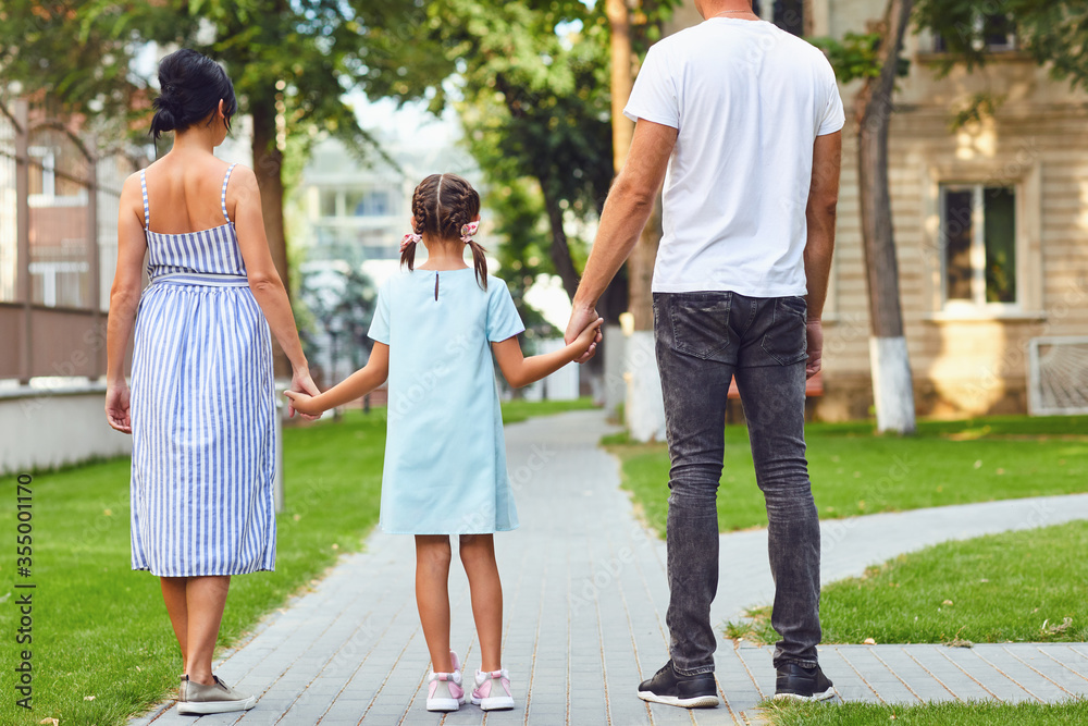 Happy family walking together in the street of the city Happy family walking together in the street of the city