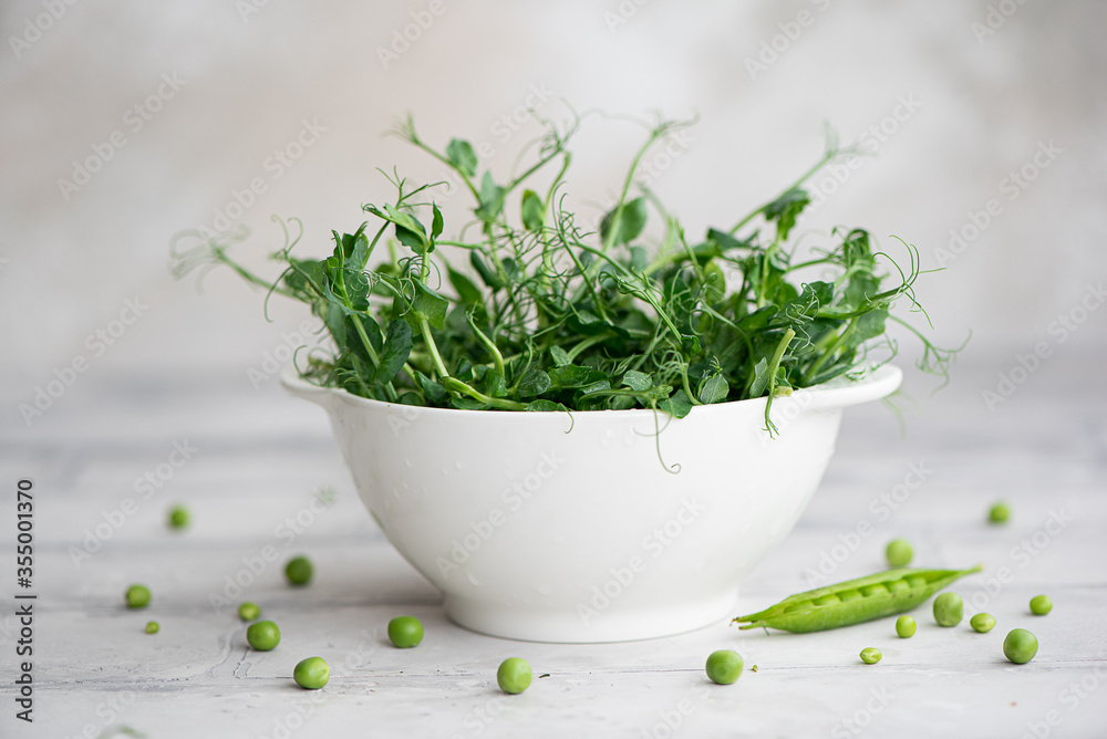 fresh microgreens of young peas in a white bowl