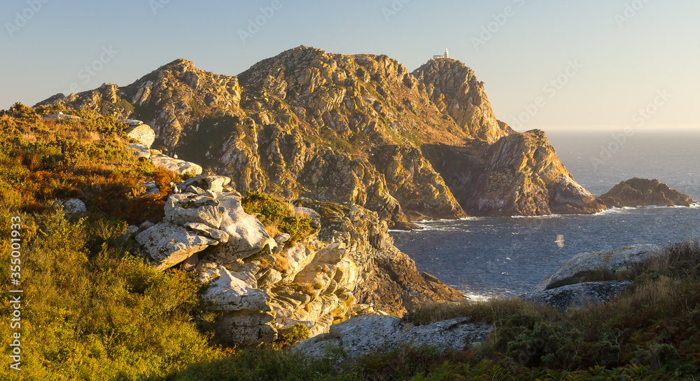 View of small island cliff at sunset