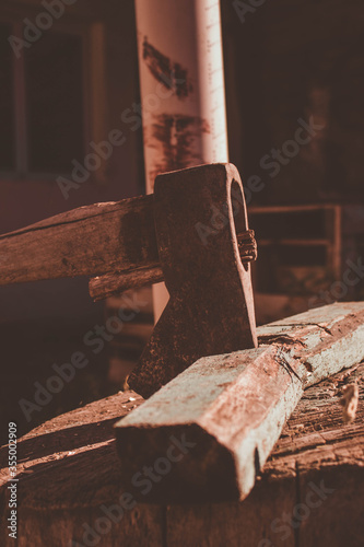 rusty ax stuck in a dry log on a sunny day