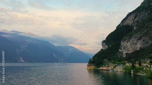 Aerial video with drone, view of the beautiful Riva del Garda town and Lake Garda lake surrounded by mountains in the autumn time , Trentino Alto Adige region, Lago di garda, italy