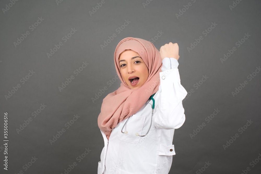 Overjoyed happy excited doctor female glad to receive good news, gestures actively from happiness, clenching fist and making winning gesture. Reaction concept. Overjoyed happy excited doctor female glad to receive good news, gestures actively from happiness, clenching fist and making winning gesture. Reaction concept.