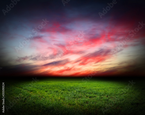 photo illustration green grass and red sky clouds spring sunset