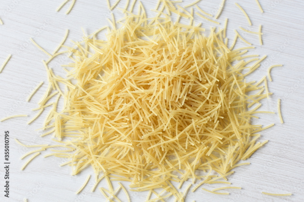 Short pasta spaghetti angel hair displayed in containers on white background