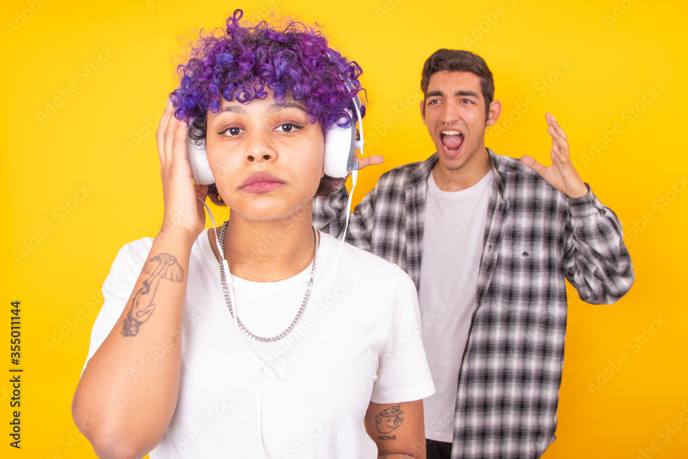 young couple with the girl with headphones and the upset boy young couple with the girl with headphones and the upset boy