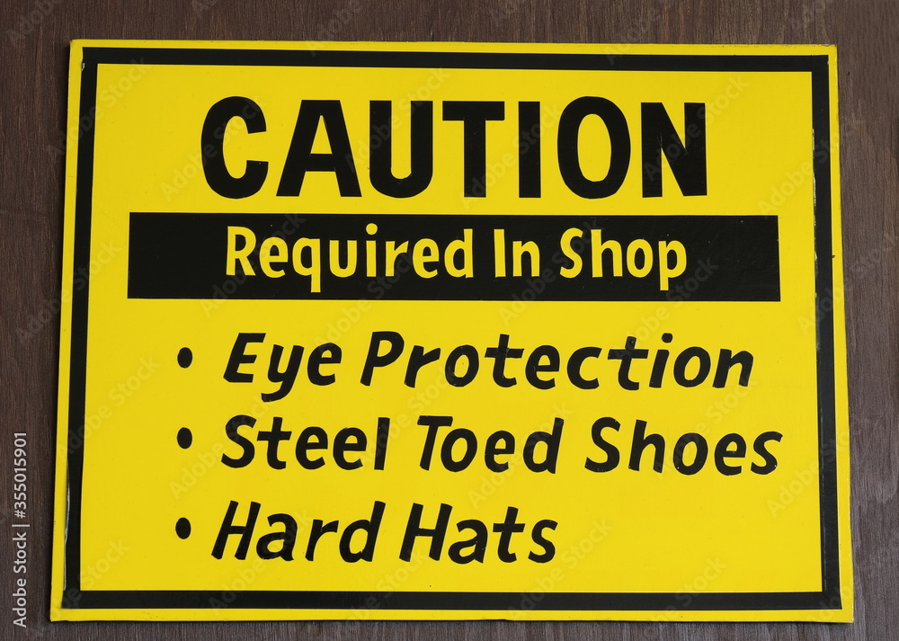 Caution Sign requiring eye protection, steel toes and hard hats in shop area
