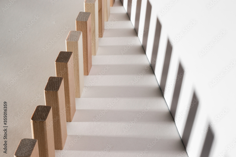 Fototapeta premium Wooden blocks in a row. Geometric shapes from light and shadow. Illusion, concept.
