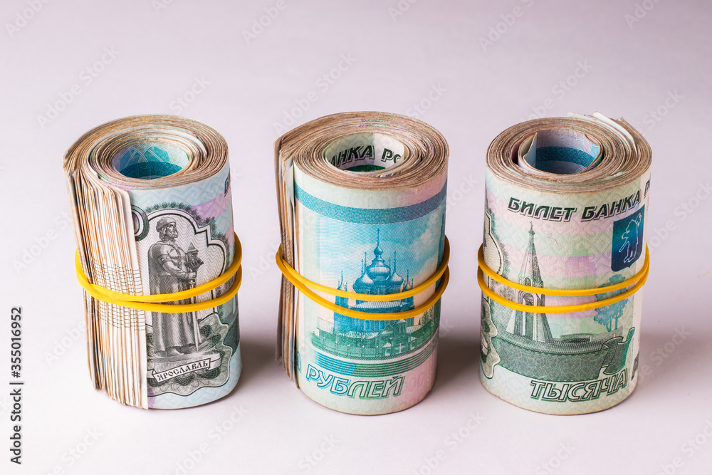 Several rolls of Russian money are pulled together with a rubber bandage. Banknotes of Russian rubles in denominations of one thousand Several rolls of Russian money are pulled together with a rubber bandage. Banknotes of Russian rubles in denominations of one thousand