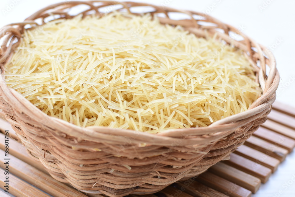 Short pasta spaghetti angel hair displayed in containers on white background