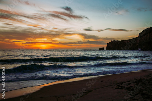 Nazare, Portugal: Sunset over Atlantic Ocean seen from the beach