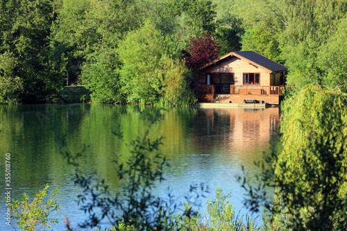 A wooden fishing lodge on the banks of a Cotswold leisure lake. UK.