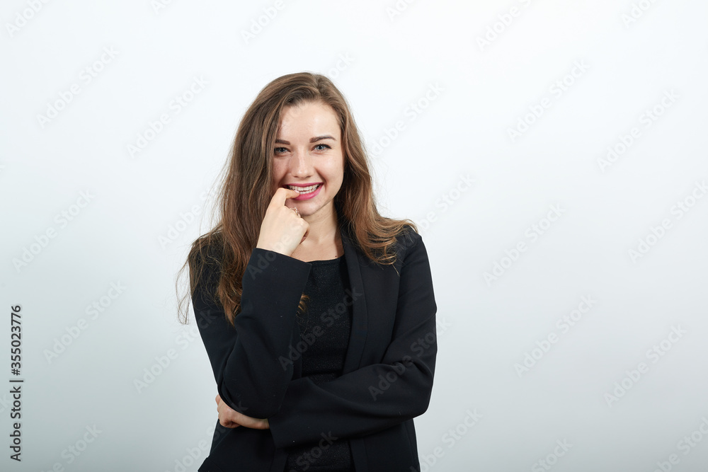 Young attractive brunette woman in a black t-shirt and sweater on white background, seductive female touches her finger to the lips. Flirtatious people Young attractive brunette woman in a black t-shirt and sweater on white background, seductive female touches her finger to the lips. Flirtatious people